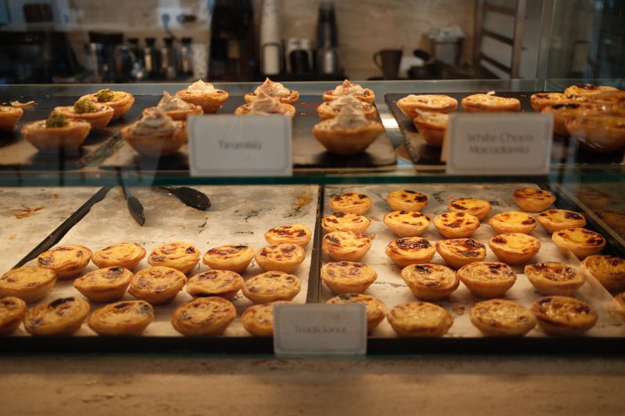 Trays of custard tarts in a bakery case