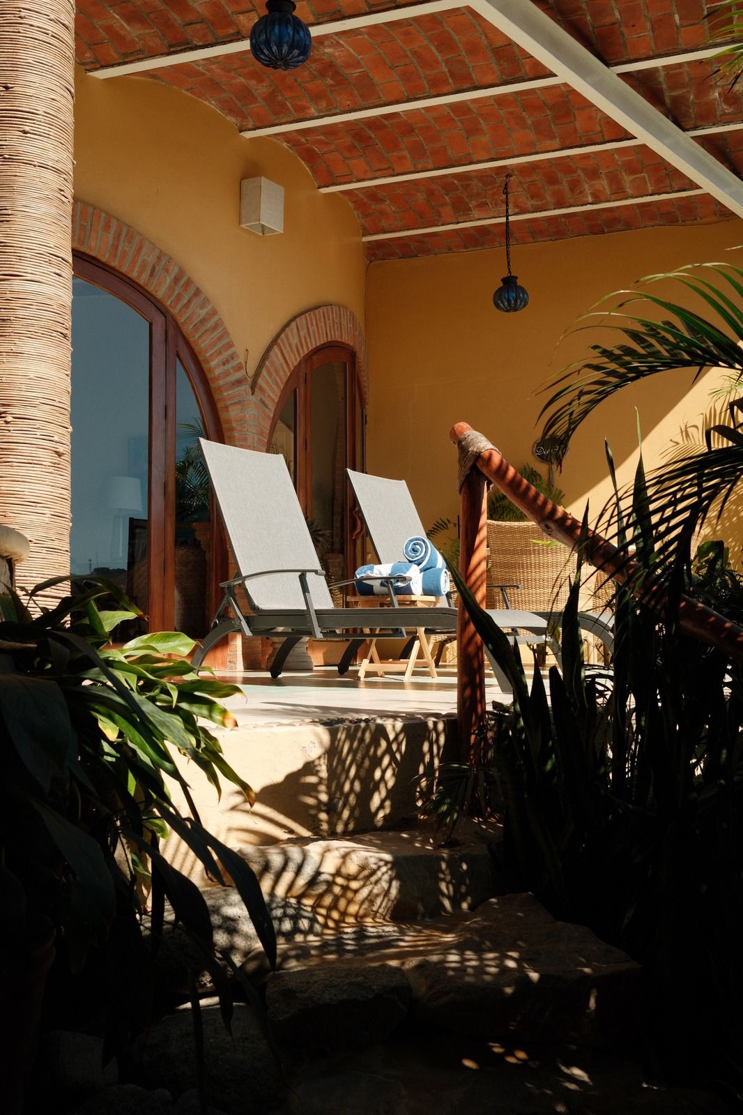 Sun loungers on a shaded terrace under a terracotta roof