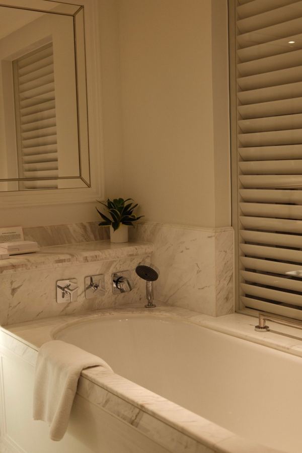 Marble soaking tub by a shuttered window