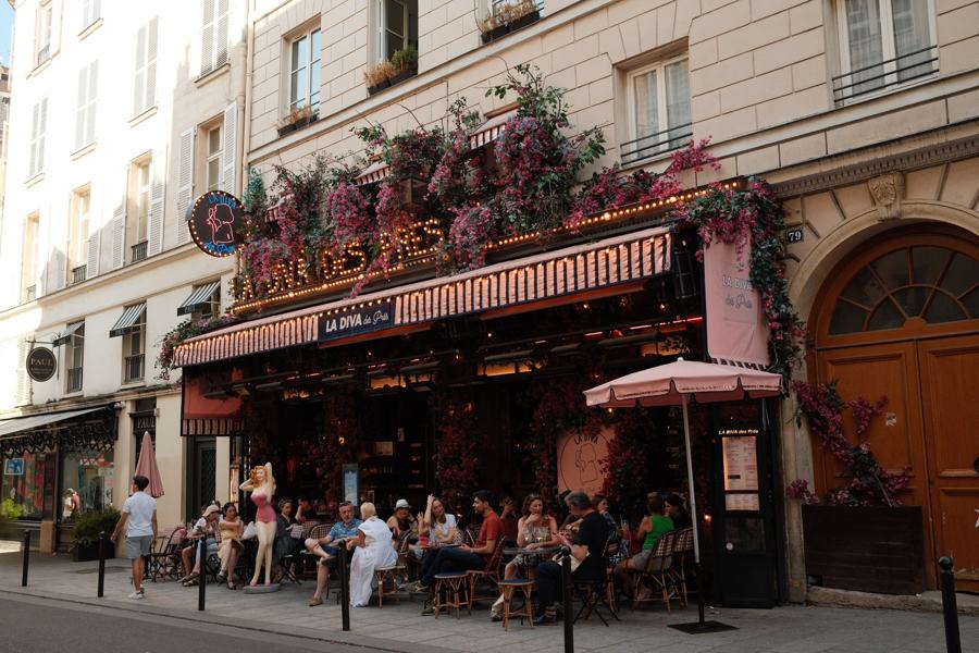 Busy café terrace under flowering balconies