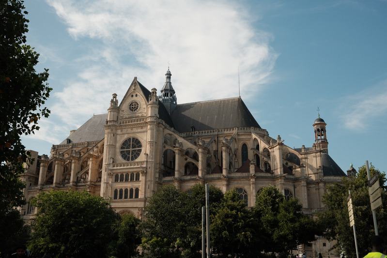 Gothic church facade above a tree-lined square