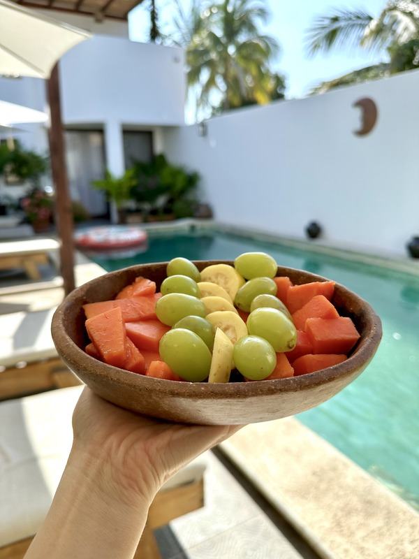 Bowl of fresh fruit held over a pool
