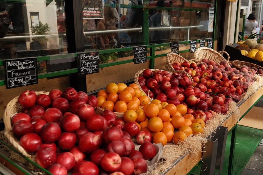 Apples and oranges stacked at a market