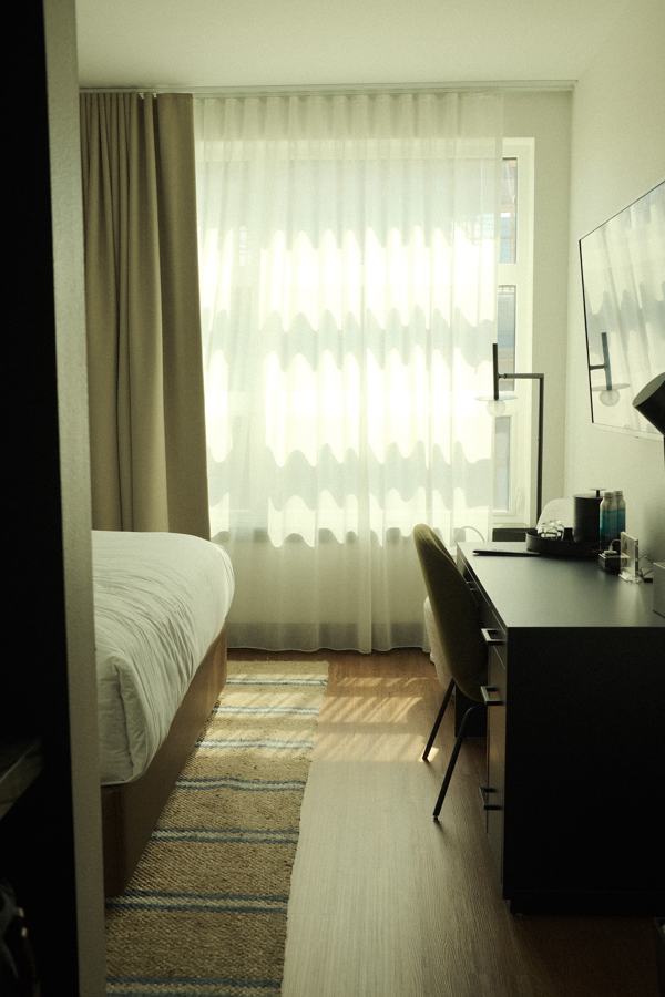 Guest room with sheer curtains and desk by the window