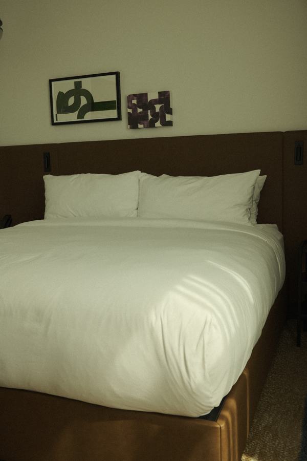 Made bed with framed art above the headboard