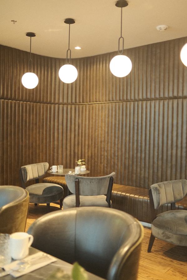 Lounge with globe pendants and channel-tufted walls