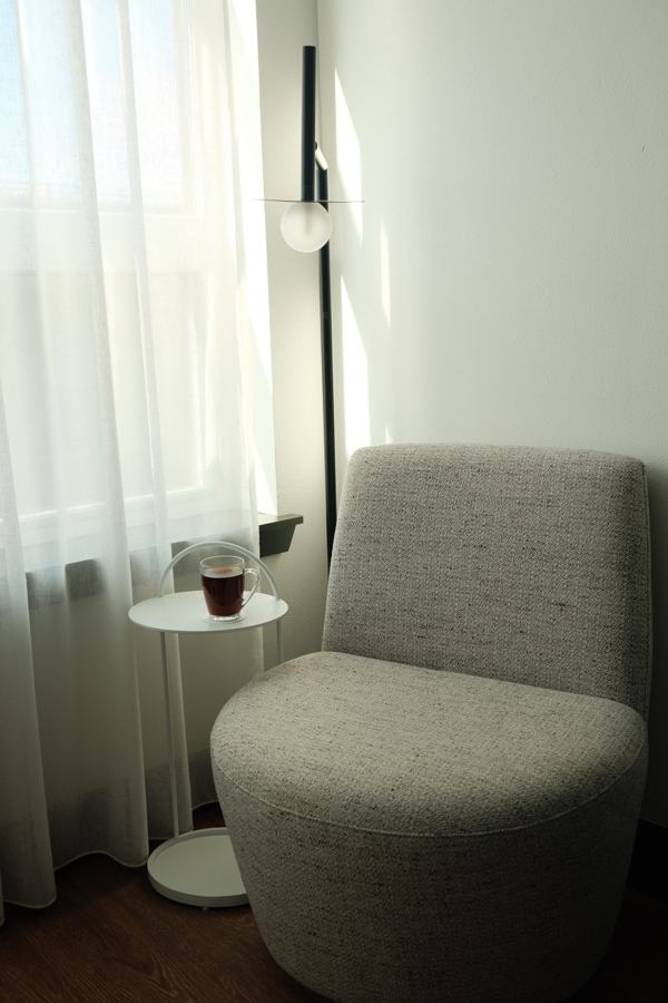 Upholstered chair and side table by a bright window